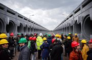 Dziennikarze, goście i robotnicy na miejscu budowy osłony w Czarnobylu