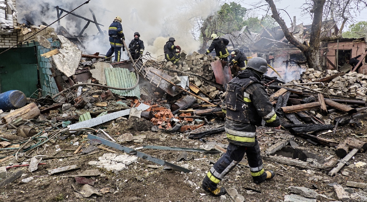 Ukraińscy ratownicy przeszukują zgliszcza cywilnego budynku zniszczonego w rosyjskim ataku rakietowym.