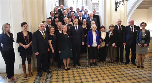 Prezydent Andrzej Duda pozuje z odznaczonymi do wspólnego zdjęcia