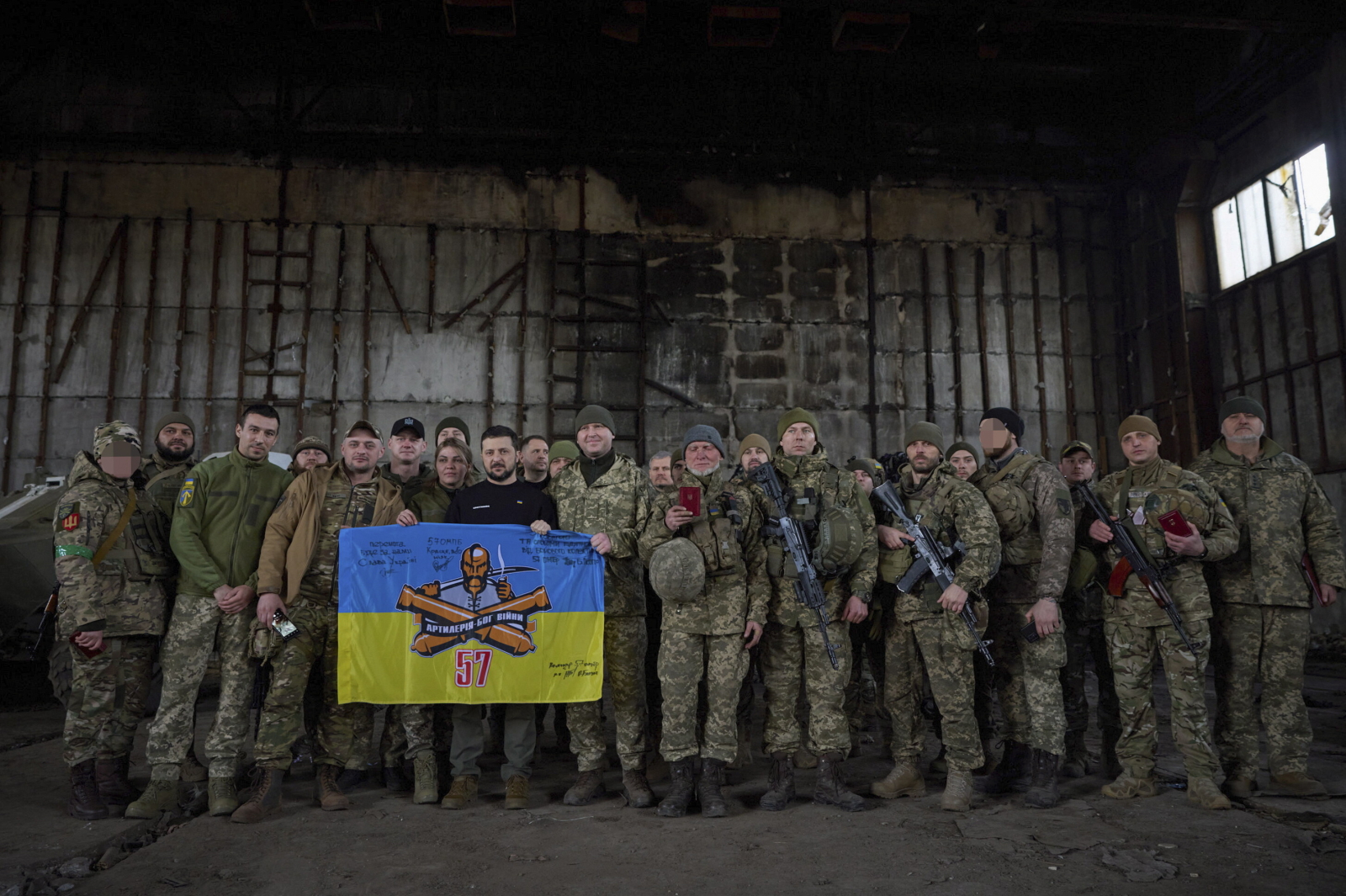 Ukrainian President Volodymyr Zelensky (8-L) poses for a photo with servicemen as he visits the advanced positions of the Ukrainian military in the Bakhmut direction, during a working trip to the Donetsk region, at an undisclosed location in Ukraine, 22 March 2023, amid the Russian invasion of the country.