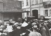 Ludzie czytający sowieckie gazety rozdawane na ulicy, z prawej stoją dwaj czerwonoarmiści, miejsce nieznane, jesień 1939