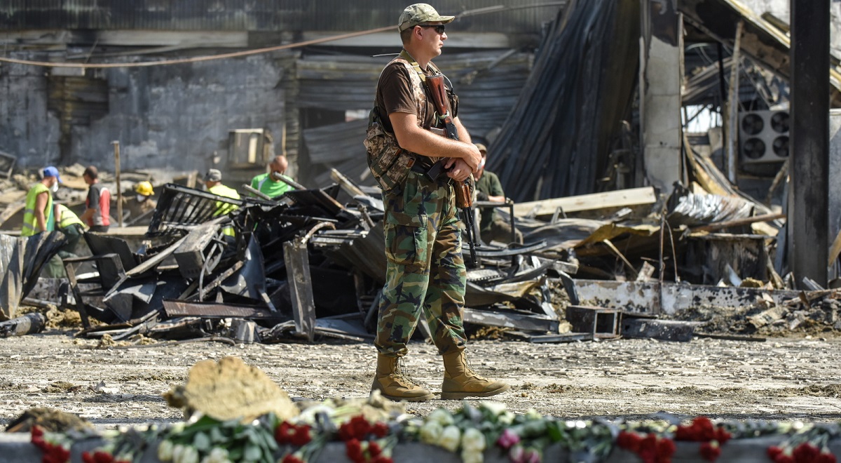 A Ukrainian serviceman stands guard near the rubble of the destroyed Amstor shopping mall in Kremenchuk, central Ukraine, on Wednesday, June 29, 2022.