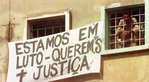 Jeden ze skazańców w oknie więzienia Carandiru w czasie wydarzeń w 1992 r. Napis na transparencie głosi: opłakujemy zmarłych, żądamy sprawiedliwości