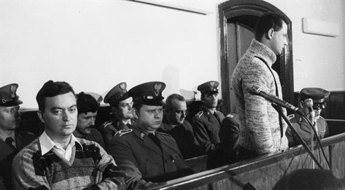 Czterej oskarżeni byli funkcjonariusze MSW na sali Sądu Wojewódzkiego w Toruniu. Stoi Leszek Pękala, za nim w marynarce w otoczeniu milicjantów siedzi Adam Pietruszka, po lewej na pierwszym planie w swetrze w paski z założonymi rękami siedzi Grzegorz Piotrowski,  grudzień 1984 r. lub styczeń 1985 r.,