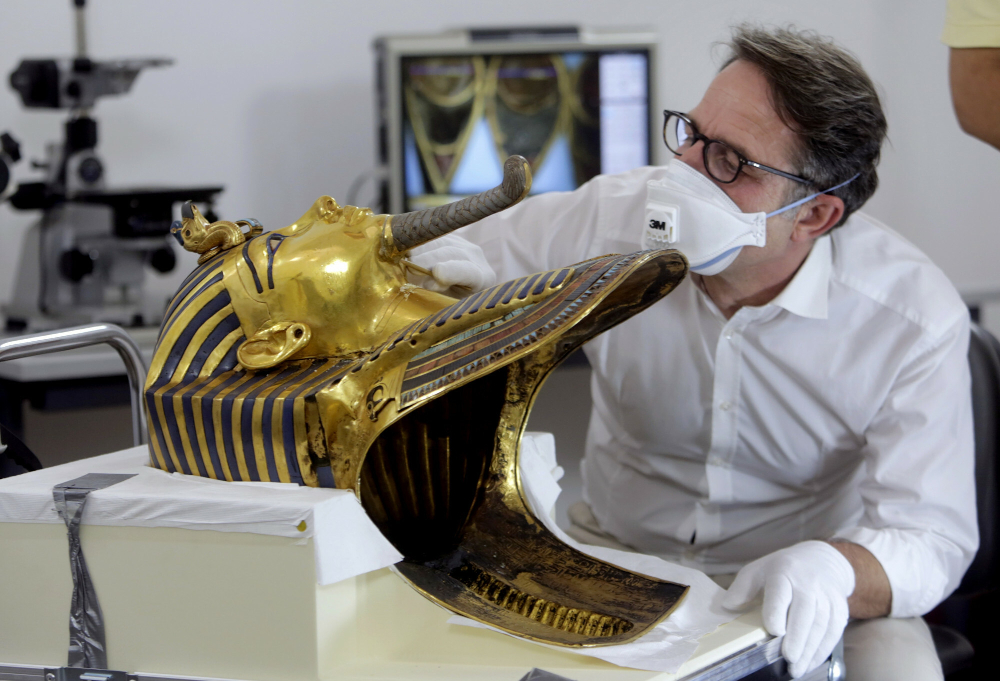 Konserwator Christian Eckmann podczas oględzin maski pogrzebowej Tutanchamona zniszczonej przez pracowników Muzeum Egipskiego. Fot. AP/East News