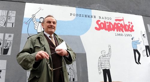 Zbigniew Romaszewski na tle muralu podziemnego Radia Solidarność