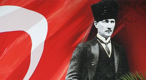 Portret Mustafy Kemal Atatrka na tle tureckiej flagi. Wikimedia Commonscc