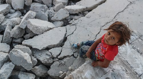 Dziecko na gruzach jednej ze zniszczonych miejscowości syryjskich
