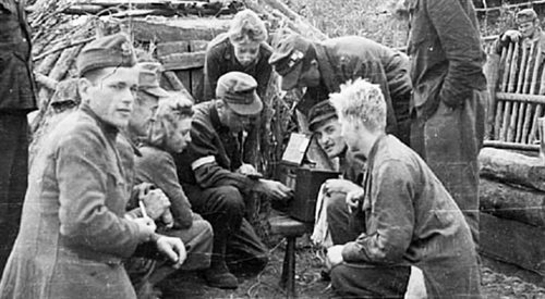 Żołnierze Kompanii Lotniczej Grupy Kampinos słuchają audycji Błyskawicy we wsi Wiersze. Około 15.09.1944