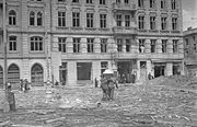 Śródmieście Północne. Grupa mężczyzn niosąca trumnę na ul. Chłodnej. W tle widoczna kamienica przy Chłodnej 16, po lewej fragment kamienicy przy Chłodnej 18, 3 sierpnia 1944.