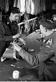 Żołnierze podczas składania i sprawdzania spadochronów. Wielka Brytania, 1944 