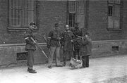 Śródmieście Północne. Patrol powstańczy pod budynkiem koszar policji przy ul. Ciepłej 13, początek sierpnia 1944.