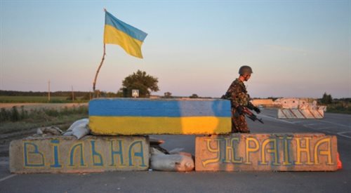 Żołnierz z ukraińskiego batalionu Ajdar w Ługańsku na wschodniej Ukrainie. Na murze napis Wolna Ukraina.