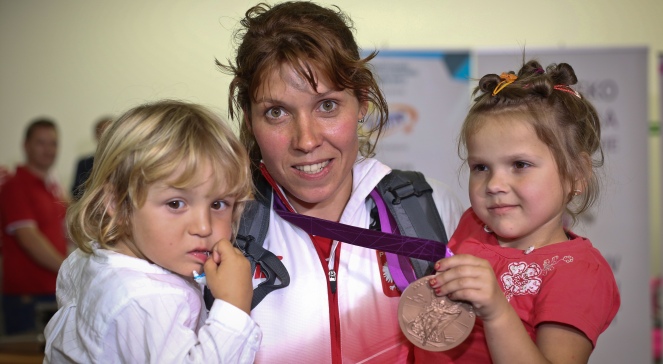 Brązowa medalistka w żeglarskiej klasie RS:X Zofia Noceti-Klepacka z synem (L) i najwierniejszym kibicem Zuzią (P) podczas powitania na lotnisku Okęcie