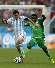 Leo Messi drybluje, Ogenyi Onasi próbuje zabrać mu piłkę