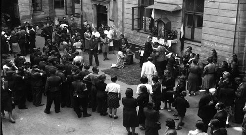 Przygotowania do mszy świętej na podwórku kamienicy (prawdopodobnie przy ul. Marszałkowskiej 40) przy kapliczce z figurą Matki Boskiej. Sierpień 1944