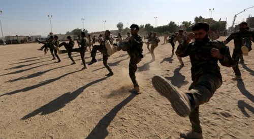 Członkowie milicji szyickich w Iraku prezentują swoje umiejętności podczas ceremonii po zakończeniu ich szkolenia w bazie wojskowej w mieście, Nadżaf południowym Iraku