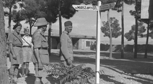 Gen. Władysław Anders (pierwszy z prawej) i gen. Władysław Sikorski w polskiej bazie wojskowej stoją przy drogowskazie - 3 km do Teheranu, 4371 km do Warszawy. Iran, 1943