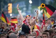 Kibice reprezentacji Niemiec przy Bramie Brandenburskiej w Berlinie oglądają przylot piłkarzy do kraju