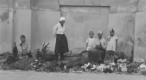 Kobiety z dziećmi sprzedające rozłożone na chodniku zioła.