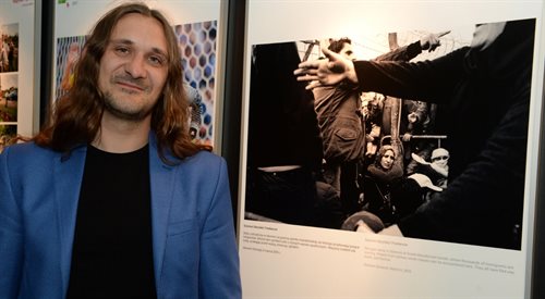 Fotoreporter Szymon Barylski przy swoim zdjęciu, podczas gali 13. edycji konkursu fotografii dokumentalnej BZ WBK Press Foto 2017
