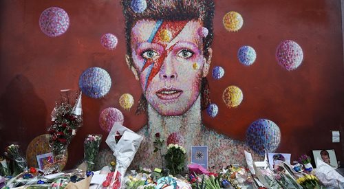 Fani oddają hołd pamięć Davida Bowiego pod przedstawiającym go muralem w Brixton