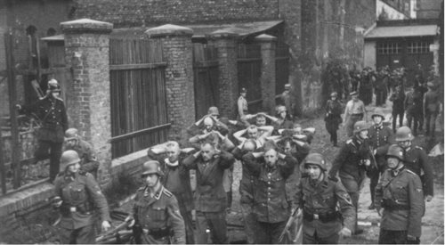 Niemieccy żołnierze prowadzą wziętych do niewoli obrońców Poczty Gdańskiej, 1 września 1939