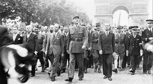 Generał Charles de Gaulle podczas parady zwycięstwa spod Łuku Triumfalnego przez Pola Elizejskie aż do Katedry Notre Dame po wyzwoleniu Paryża w sierpniu 1944 r., Muzeum Wojenne w Wielkiej Brytanii