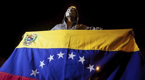 Zwolennik wenezuelskiej opozycji, ukrywający twarz w masce, świętuje zwycięstwo Opozycyjna Koalicja na rzecz Jedności Demokratycznej (MUD), Caracas 7.12.2015