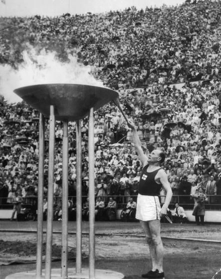 Fiński lekkoatleta Paavo Nurmi rozpala znicz olimpijski podczas IX Igrzysk Olimpijskich, które odbyły się w 1952 roku w Helsinkach. Źródło: Wikimedia commons/Domena publiczna
