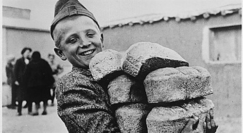 Chłopiec z zapasem chleba upieczonego z mąki podarowanej przez Amerykański Czerwony Krzyż (1943)