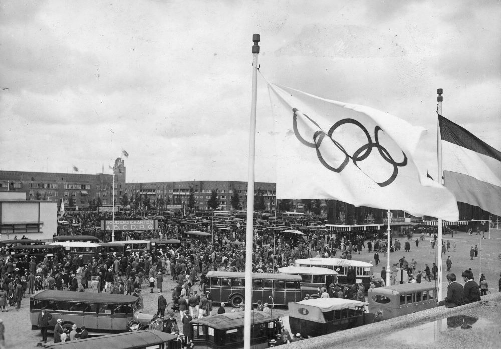 Flaga olimpijska powiewająca na wietrze podczas Igrzysk Olimpijskich, które odbyły się w 1928 roku w Amsterdamie. Źródło: NAC/Domena publiczna
